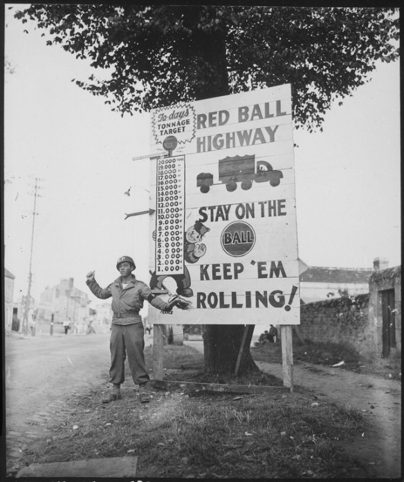 Corporal_Charles_H._Johnson_of_the_783rd_Military_Police_Battalion,_waves_on_a_-Red_Ball_Express-_motor_convoy..._-_NARA_-_531220.tif